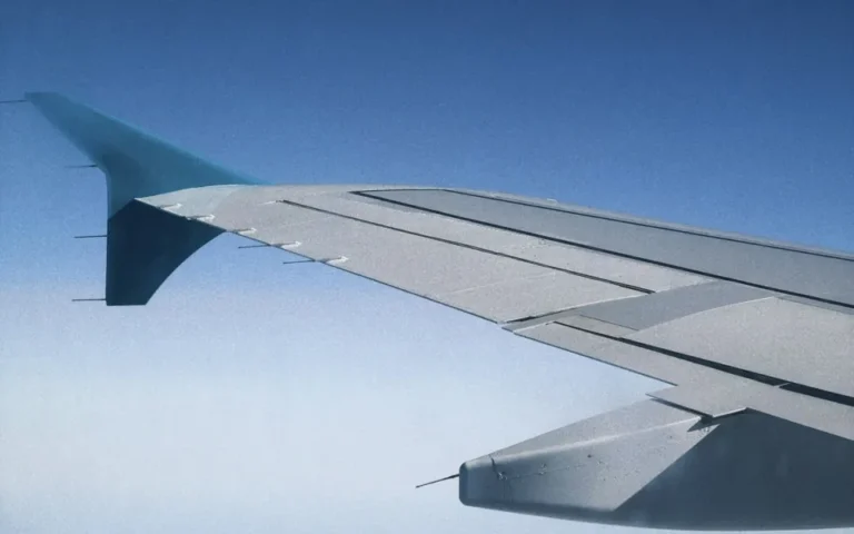 Airplane wing against a clear blue sky