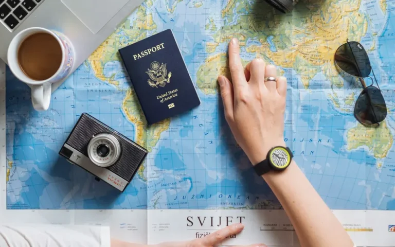 Travel planning with world map, passport, camera, and laptop
